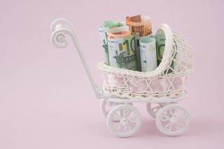 © dewessa - stock.adobe.com Foto: Miniaturkinderwagen mit Geldscheinen